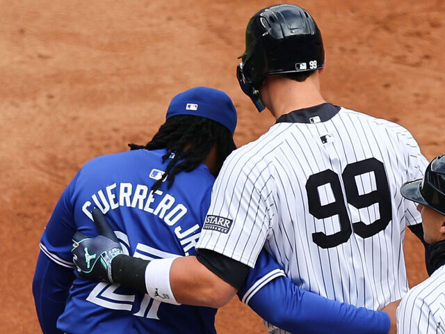 BRONX, NY - APRIL 05: Aaron Judge #99 of the New York Yankees and Vladimir Guerrero Jr. #27 of the Toronto Blue Jays hug during the game on April 5, 2024 at Yankee Stadium in the Bronx, New York.