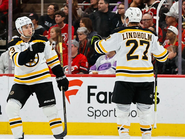RALEIGH, NC - OCTOBER 31: Charlie McAvoy #73 of the Boston Bruins and Hampus Lindholm #27 celebrate during the second period of the game against the Carolina Hurricanes at Lenovo Center on October 31, 2024 in Raleigh, North Carolina. Canes defeat the Bruins 8-2.