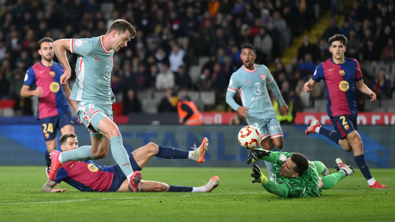 BARCELONA, SPAIN - FEBRUARY 25: Alexander Sorloth of Atletico de Madrid scores his team's fourth goal past Wojciech Szczesny of FC Barcelona during the Copa del Rey Semi Final match between FC Barcelona and Atletico de Madrid at Estadi Olimpic Lluis Companys on February 25, 2025 in Barcelona, Spain.
