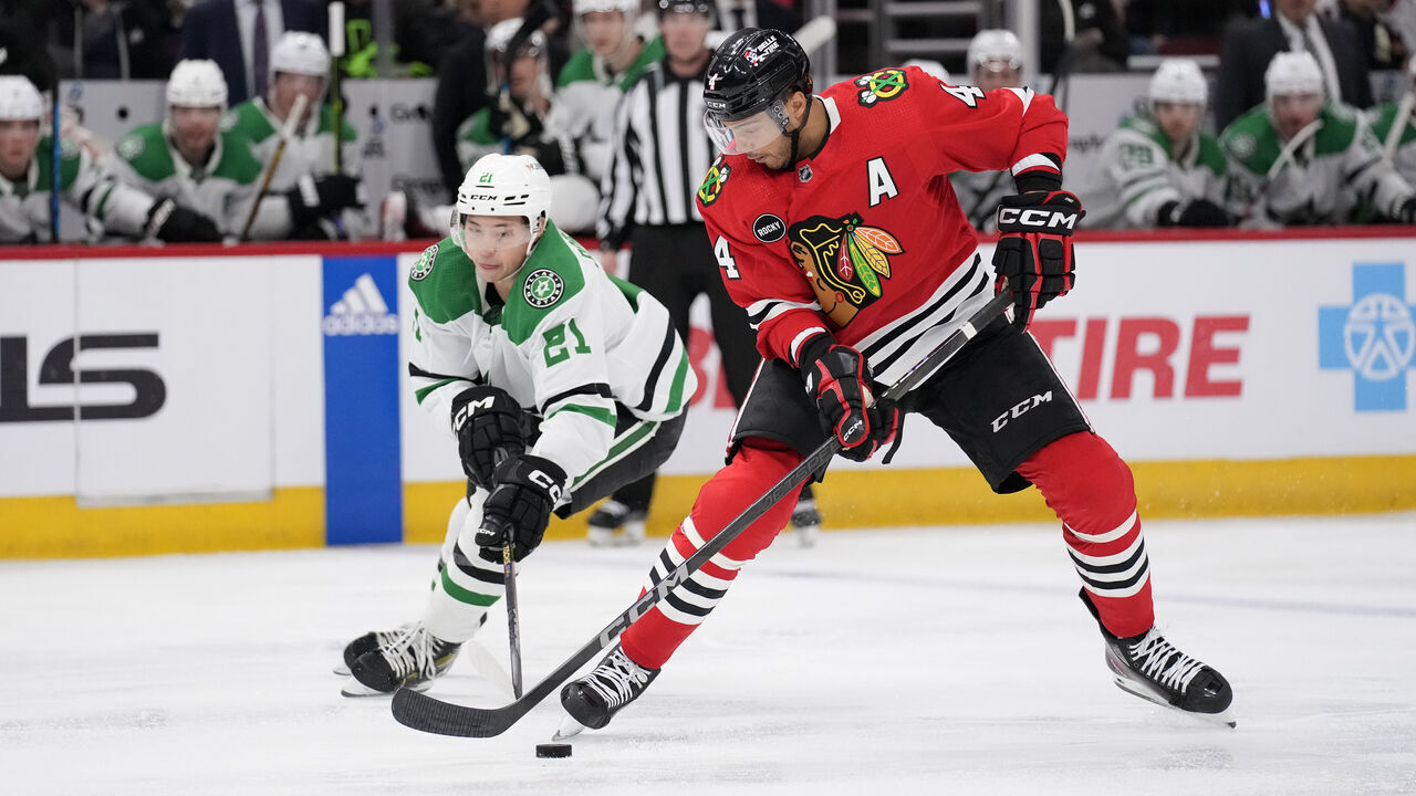 CHICAGO, ILLINOIS - APRIL 06: Seth Jones #4 of the Chicago Blackhawks skates with the puck against Jason Robertson #21 of the Dallas Stars during the third period at the United Center on April 06, 2024 in Chicago, Illinois.