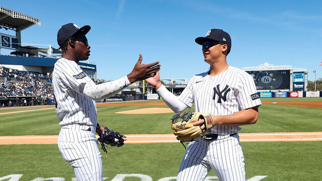 TAMPA, FL - FEBRUARY 21: Jazz Chisholm Jr. #13 and Anthony Volpe #11 of the New York Yankees high five before a spring training game against the Tampa Bay Rays at George M. Steinbrenner Field on February 21, 2025 in Tampa, Florida.