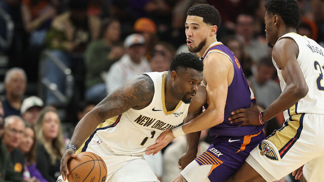 PHOENIX, ARIZONA - FEBRUARY 27: Zion Williamson #1 of the New Orleans Pelicans handles the ball against Devin Booker #1 of the Phoenix Suns during the first half of the NBA game at Footprint Center on February 27, 2025 in Phoenix, Arizona.