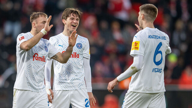 02 March 2025, Berlin: Soccer: Bundesliga, 1. FC Union Berlin - Holstein Kiel, Matchday 24, An der Alten Försterei. Dominik Javorcek (l-r), Magnus Knudsen and Marko Ivezic of Holstein Kiell celebrate after the win. Photo: Andreas Gora/dpa - IMPORTANT NOTE: In accordance with the regulations of the DFL German Football League and the DFB German Football Association, it is prohibited to utilize or have utilized photographs taken in the stadium and/or of the match in the form of sequential images and/or video-like photo series.