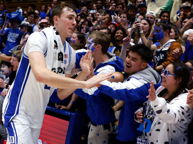 DURHAM, NORTH CAROLINA - MARCH 3: Cooper Flagg #2 of the Duke Blue Devils high-fives fans following their 93-60 victory against the Wake Forest Demon Deacons at Cameron Indoor Stadium on March 3, 2025 in Durham, North Carolina.