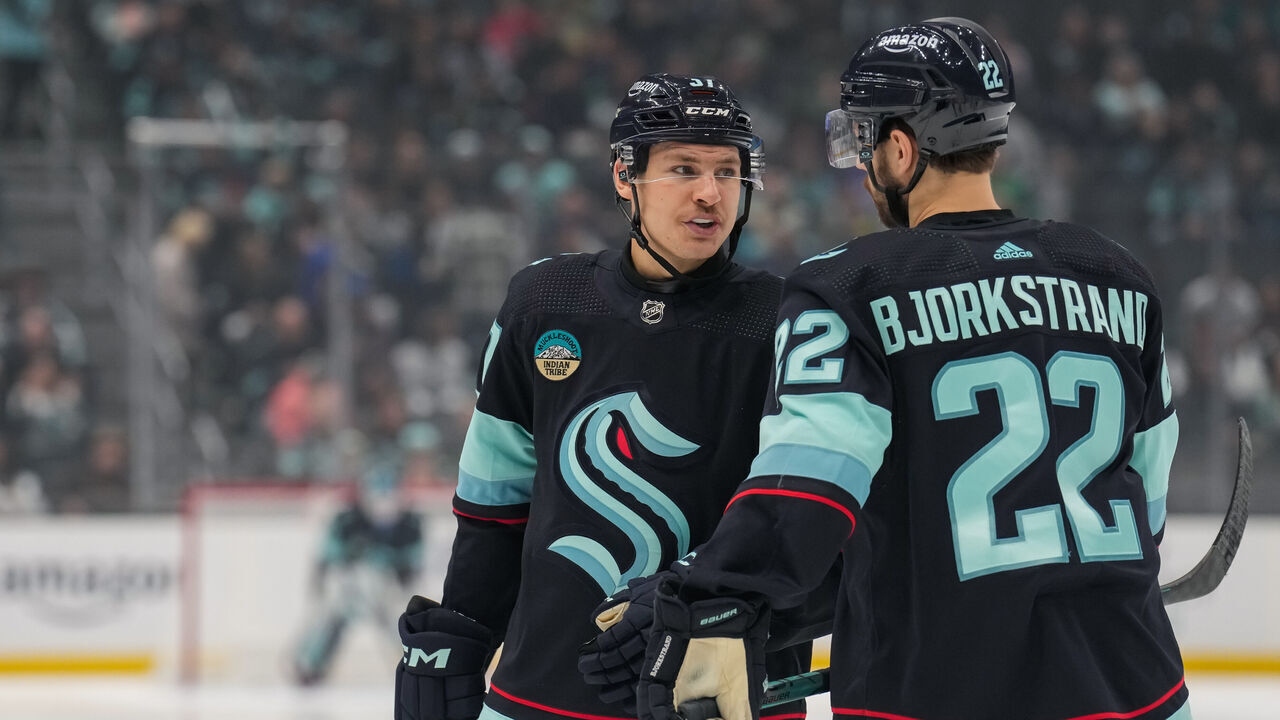 SEATTLE, WASHINGTON - NOVEMBER 22: Yanni Gourde #37 of the Seattle Kraken talks with teammate Oliver Bjorkstrand #22 before a face-off during the first period of a game against the San Jose Sharks at Climate Pledge Arena on November 22, 2023 in Seattle, Washington.