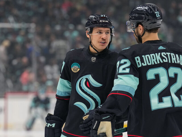 SEATTLE, WASHINGTON - NOVEMBER 22: Yanni Gourde #37 of the Seattle Kraken talks with teammate Oliver Bjorkstrand #22 before a face-off during the first period of a game against the San Jose Sharks at Climate Pledge Arena on November 22, 2023 in Seattle, Washington.