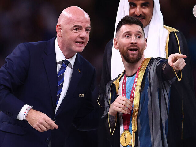 LUSAIL CITY, QATAR - DECEMBER 18: Lionel Messi of Argentina gestures before receiving the FIFA World Cup trophy from FIFA President Gianni Infantino as Sheikh Tamim bin Hamad Al Thani, Emir of Qatar looks on during the FIFA World Cup Qatar 2022 Final match between Argentina and France at Lusail Stadium on December 18, 2022 in Lusail City, Qatar.