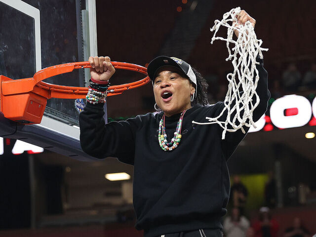 GREENVILLE, SC - MARCH 09: South Carolina Gamecocks head coach Dawn Staley holds up the net after cutting the last piece during the championship game of the SEC women's college basketball tournament between the Texas Longhorns and the South Carolina Gamecocks on March 9, 2025 at Bon Secours Wellness Arena in Greenville, S.C.