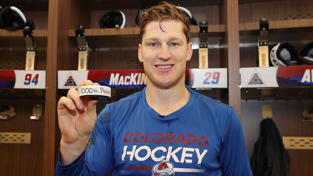 DENVER, COLORADO - MARCH 10: Nathan MacKinnon #29 of the Colorado Avalanche poses with the puck from his one thousandth career point after the game against the Chicago Blackhawks at Ball Arena on March 10, 2025 in Denver, Colorado.