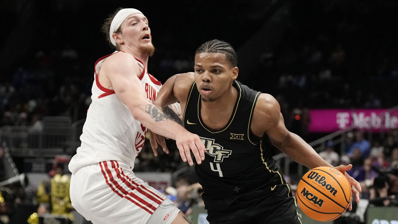 KANSAS CITY, MISSOURI - MARCH 11: Keyshawn Hall #4 of the UCF Knights drives against Gabe Madsen #55 of the Utah Utes in the first half of a first round game of the Big 12 Basketball Tournament at T-Mobile Center on March 11, 2025 in Kansas City, Missouri.