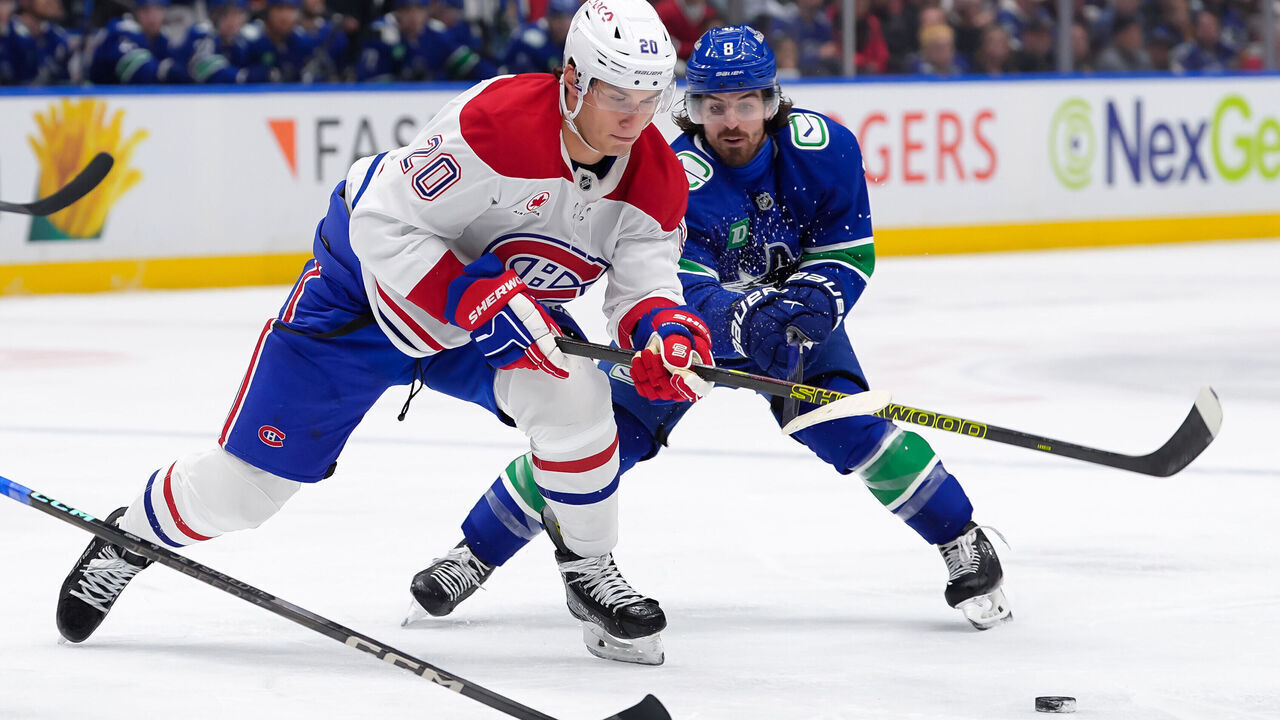 VANCOUVER, CANADA - MARCH 11: Juraj Slafkovsky #20 of the Montréal Canadiens is checked by Conor Garland #8 of the Vancouver Canucks during the second period at Rogers Arena on March 11, 2025 in Vancouver, British Columbia, Canada. 2