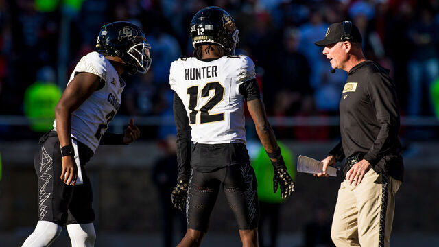 LUBBOCK, TEXAS - NOVEMBER 09: Shedeur Sanders #2 and Travis Hunter #12 of the Colorado Buffaloes talk with offensive coordinator Pat Shurmur during the first half of the game against the Texas Tech Red Raiders at Jones AT&T Stadium on November 09, 2024 in Lubbock, Texas.