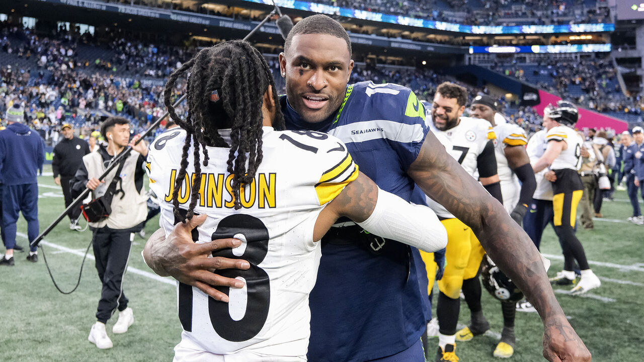 SEATTLE, WASHINGTON - DECEMBER 31: DK Metcalf #14 of the Seattle Seahawks and Diontae Johnson #18 of the Pittsburgh Steelers hug after a game at Lumen Field on December 31, 2023 in Seattle, Washington.