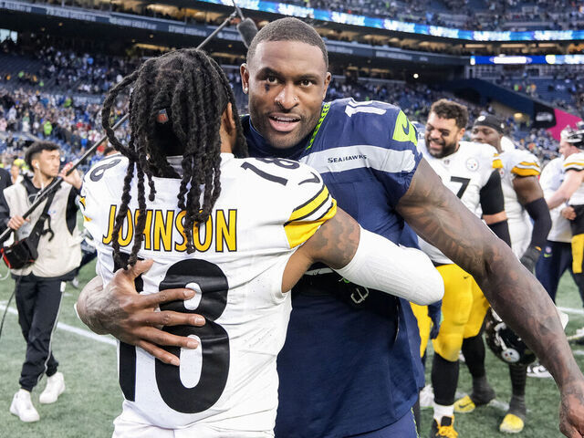 SEATTLE, WASHINGTON - DECEMBER 31: DK Metcalf #14 of the Seattle Seahawks and Diontae Johnson #18 of the Pittsburgh Steelers hug after a game at Lumen Field on December 31, 2023 in Seattle, Washington.