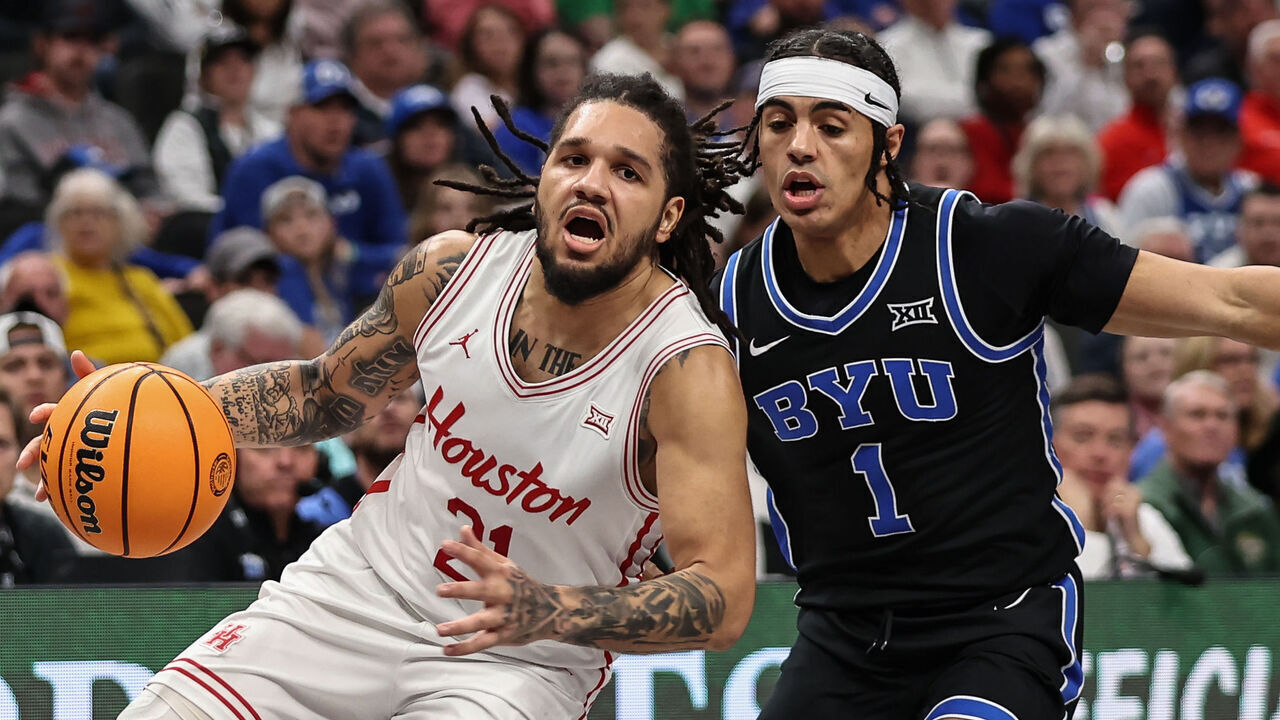 KANSAS CITY, MO - MARCH 14: Houston Cougars guard Emanuel Sharp (21) drives past Brigham Young Cougars guard Trey Stewart (1) in the first half of a Big 12 tournament semifinal game between the BYU Cougars and Houston Cougars on March 14, 2025 at T-Mobile Center in Kansas City, MO.