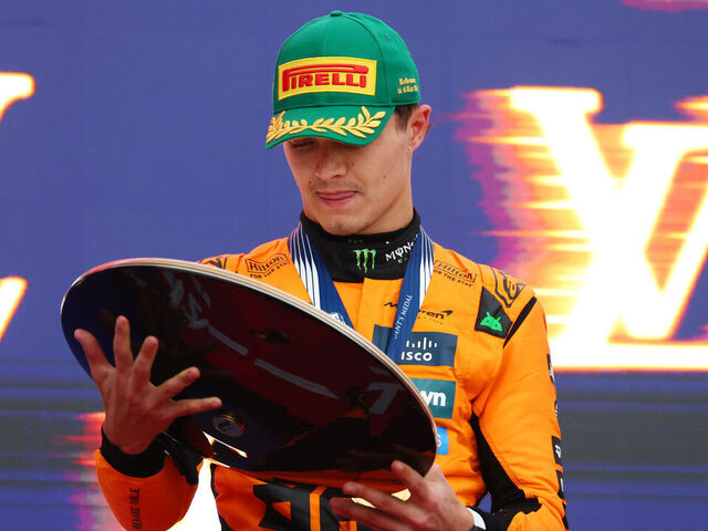 MELBOURNE, AUSTRALIA - MARCH 16: Race winner Lando Norris of Great Britain and McLaren inspects his trophy on the podium during the F1 Grand Prix of Australia at Albert Park Grand Prix Circuit on March 16, 2025 in Melbourne, Australia.