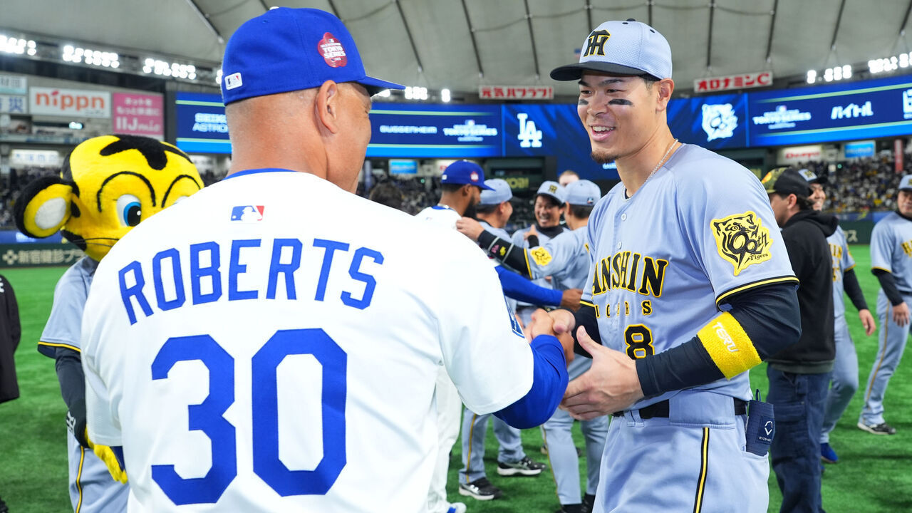 TOKYO, JAPAN - MARCH 16: Teruaki Sato #8 of the Hanshin Tigers is congratulated by Manager Dave Roberts #30 of the Los Angeles Dodgers after the game at Tokyo Dome on March 16, 2025 in Tokyo, Japan.