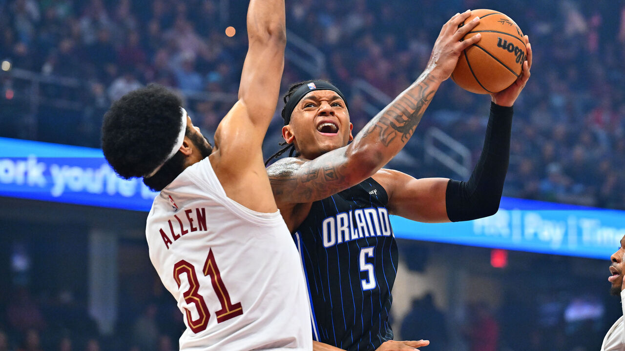 CLEVELAND, OHIO - MARCH 16: Paolo Banchero #5 of the Orlando Magic drives to the basket around Jarrett Allen #31 of the Cleveland Cavaliers during the first quarter at Rocket Arena on March 16, 2025 in Cleveland, Ohio.