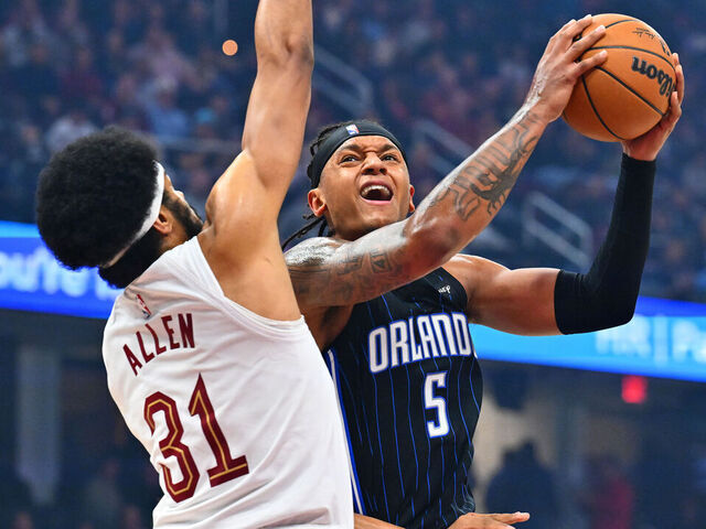 CLEVELAND, OHIO - MARCH 16: Paolo Banchero #5 of the Orlando Magic drives to the basket around Jarrett Allen #31 of the Cleveland Cavaliers during the first quarter at Rocket Arena on March 16, 2025 in Cleveland, Ohio.