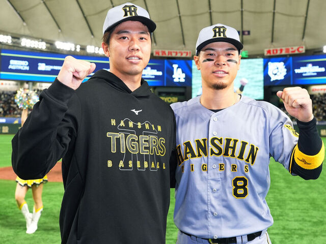 TOKYO, JAPAN - MARCH 16: Hiroto Saiki #35 and Teruaki Sato #8 of the Hanshin Tigers pose after the team's 3-0 victory against Los Angeles Dodgers at Tokyo Dome on March 16, 2025 in Tokyo, Japan.