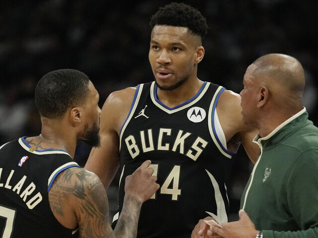 MILWAUKEE, WISCONSIN - APRIL 07: Damian Lillard #0, Giannis Antetokounmpo #34 and ead coach Doc Rivers of the Milwaukee Bucks talk during the first half of the game against the New York Knicks at Fiserv Forum on April 07, 2024 in Milwaukee, Wisconsin.