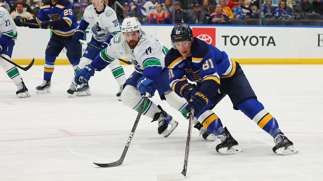 ST LOUIS, MISSOURI - JANUARY 27: Dylan Holloway #81 of the St. Louis Blues controls the puck against Filip Hronek #17 of the Vancouver Canucks in the third period at Enterprise Center on January 27, 2025 in St Louis, Missouri.