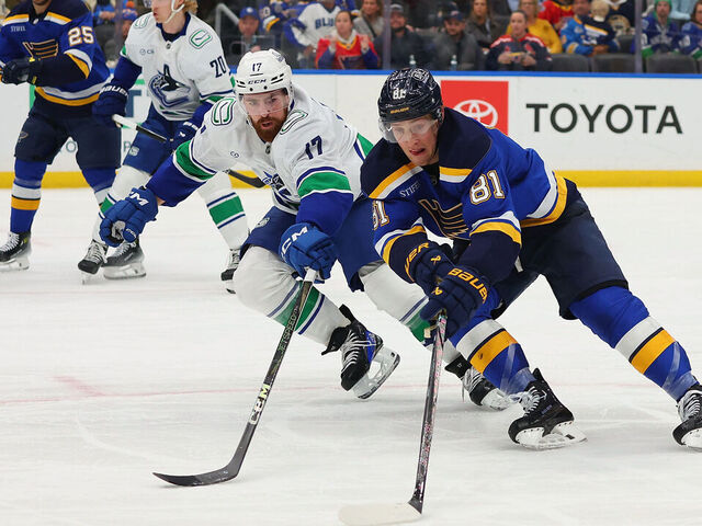 ST LOUIS, MISSOURI - JANUARY 27: Dylan Holloway #81 of the St. Louis Blues controls the puck against Filip Hronek #17 of the Vancouver Canucks in the third period at Enterprise Center on January 27, 2025 in St Louis, Missouri.