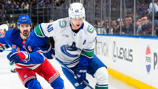 NEW YORK, NEW YORK - MARCH 22: Elias Pettersson #40 of the Vancouver Canucks skates with the puck against Chris Kreider #20 of the New York Rangers at Madison Square Garden on March 22, 2025 in New York City.