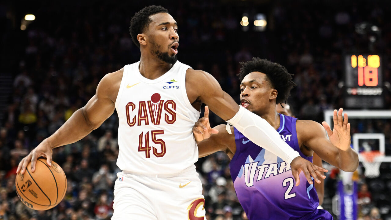 SALT LAKE CITY, UTAH - MARCH 23: Donovan Mitchell #45 of the Cleveland Cavaliers passes around Collin Sexton #2 of the Utah Jazz during the first half of a game at Delta Center on March 23, 2025 in Salt Lake City, Utah.