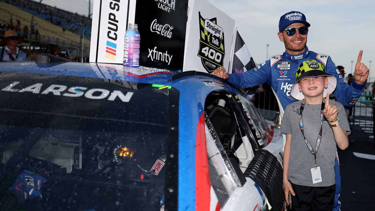 HOMESTEAD, FLORIDA - MARCH 23: Kyle Larson, driver of the #5 HendrickCars.com Chevrolet, and son, Owen Larson pose with the winner sticker on his car in victory lane after winning the NASCAR Cup Series Straight Talk Wireless 400 at Homestead-Miami Speedway on March 23, 2025 in Homestead, Florida.