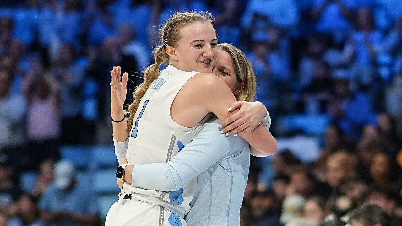 CHAPEL HILL, NORTH CAROLINA - MARCH 24: Alyssa Ustby #1 of the North Carolina Tar Heels embraces head coach Courtney Banghart during the second half in the second round of the NCAA Women's Basketball Tournament against the West Virginia Mountaineers at Carmichael Arena on March 24, 2025 in Chapel Hill, North Carolina.