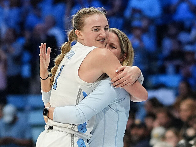 CHAPEL HILL, NORTH CAROLINA - MARCH 24: Alyssa Ustby #1 of the North Carolina Tar Heels embraces head coach Courtney Banghart during the second half in the second round of the NCAA Women's Basketball Tournament against the West Virginia Mountaineers at Carmichael Arena on March 24, 2025 in Chapel Hill, North Carolina.