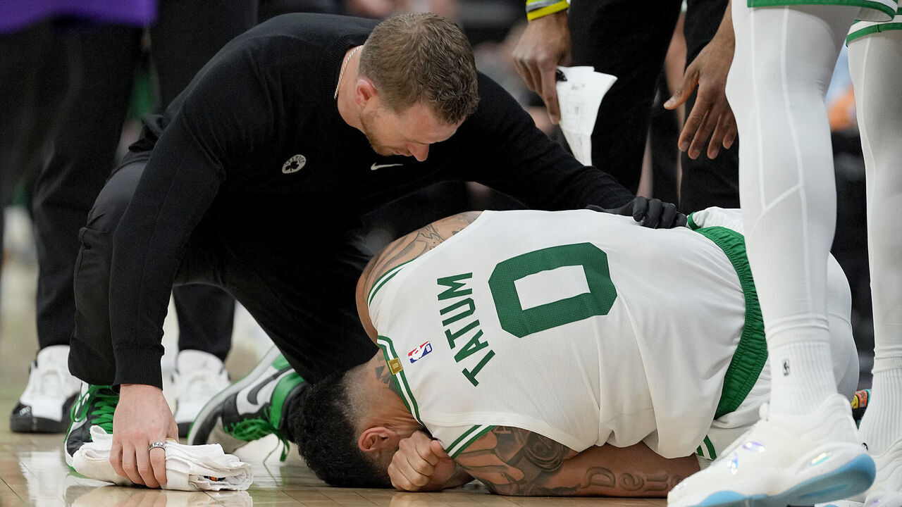 SACRAMENTO, CALIFORNIA - MARCH 24: Jayson Tatum #0 of the Boston Celtics lays on the floor in pain after turning his ankle, landing on the foot of Domantas Sabonis #11 of the Sacramento Kings during the second half at Golden 1 Center on March 24, 2025 in Sacramento, California.