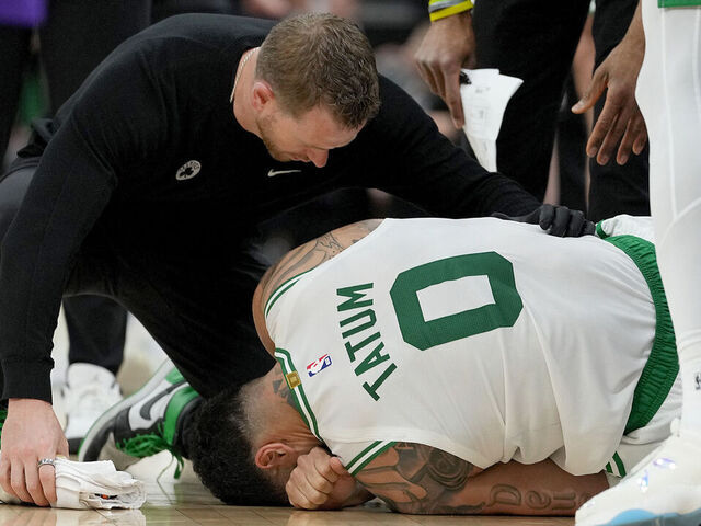 SACRAMENTO, CALIFORNIA - MARCH 24: Jayson Tatum #0 of the Boston Celtics lays on the floor in pain after turning his ankle, landing on the foot of Domantas Sabonis #11 of the Sacramento Kings during the second half at Golden 1 Center on March 24, 2025 in Sacramento, California.