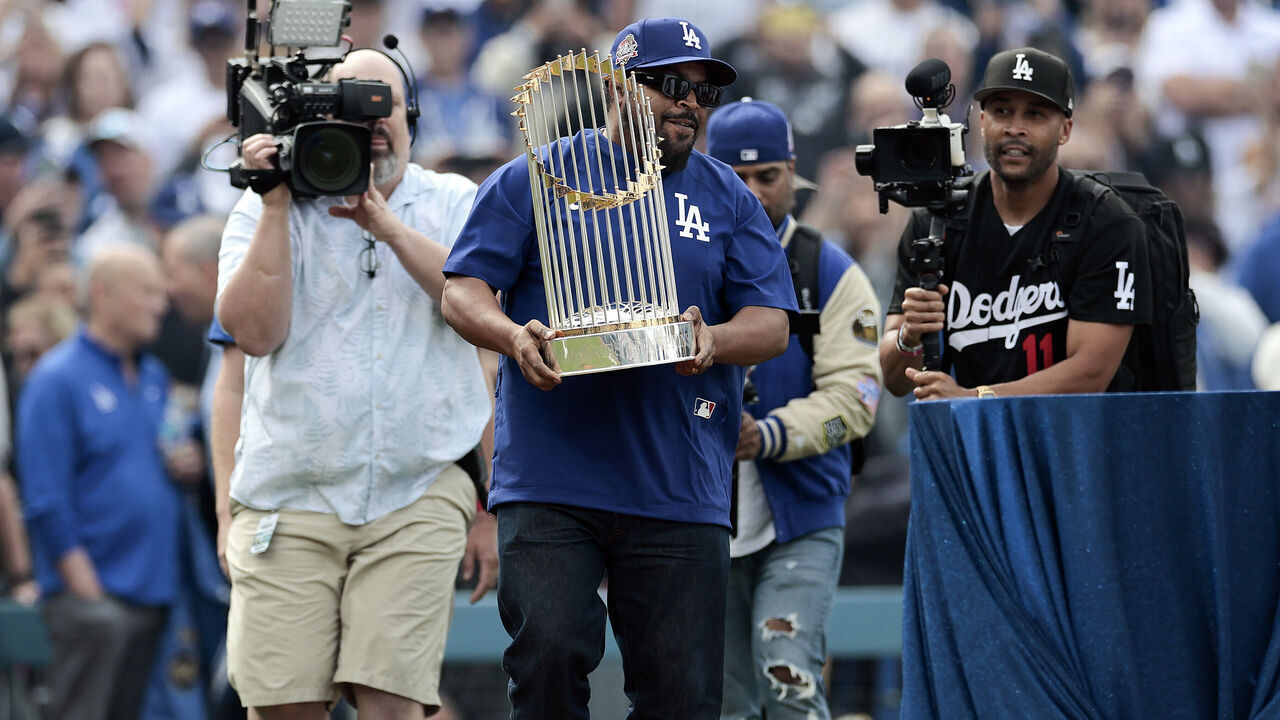 LOS ANGELES, CALIFORNIA - MARCH 27: Ice Cube presents the World series trophy prior to the game between the Los Angeles Dodgers and the Detroit Tigers on Opening Day at Dodger Stadium on March 27, 2025 in Los Angeles, California.