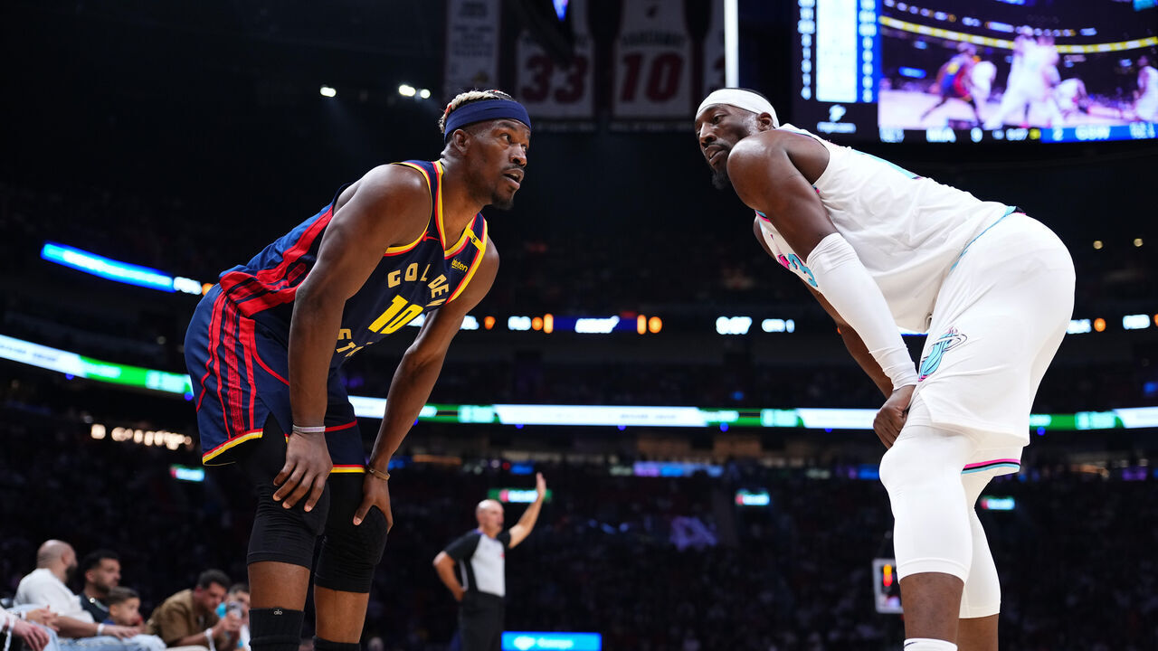 MIAMI, FLORIDA - MARCH 25: Jimmy Butler III #10 of the Golden State Warriors and Bam Adebayo #13 of the Miami Heat look on during the first quarter at Kaseya Center on March 25, 2025 in Miami, Florida.