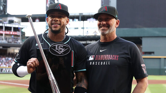 PHOENIX, ARIZONA - MARCH 29: Ketel Marte #4 poses with manager Torey Lovullo #17 of the Arizona Diamondbacks after being presented with the 2024 National League second base Silver Slugger Award before the game against the Chicago Cubs at Chase Field on March 29, 2025 in Phoenix, Arizona.