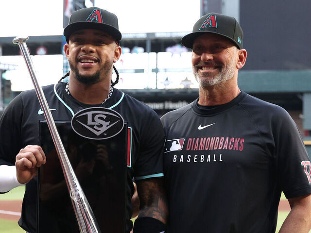 PHOENIX, ARIZONA - MARCH 29: Ketel Marte #4 poses with manager Torey Lovullo #17 of the Arizona Diamondbacks after being presented with the 2024 National League second base Silver Slugger Award before the game against the Chicago Cubs at Chase Field on March 29, 2025 in Phoenix, Arizona.