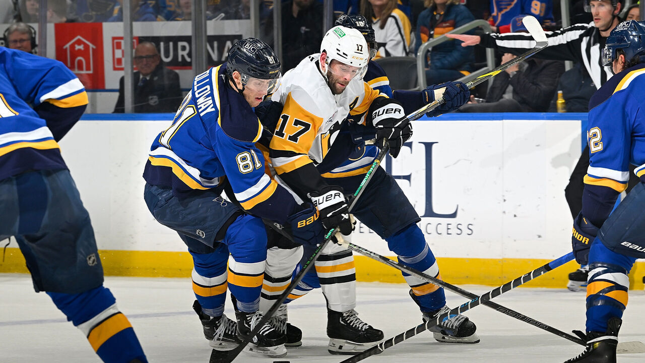 ST. LOUIS, MO - APRIL 3: Dylan Holloway #81 of the St. Louis Blues defends against Bryan Rust #17 of the Pittsburgh Penguins on April 3, 2025 at the Enterprise Center in St. Louis, Missouri.