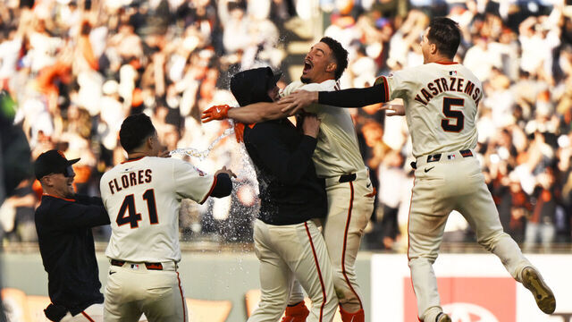 SAN FRANCISCO, CALIFORNIA - APRIL 04: The San Francisco Giants celebrate with Willy Adames #2 of the San Francisco Giants after his walk-off hit in the eleventh inning during the home opener at Oracle Park on April 04, 2025 in San Francisco, California.