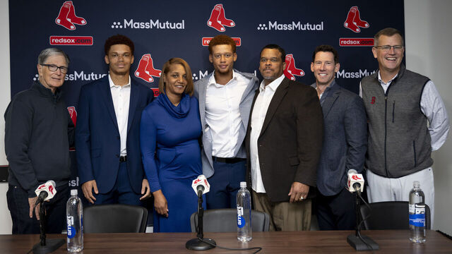 BOSTON, MASSACHUSETTS - APRIL 5: Kristian Campbell #28 of the Boston Red Sox poses for a photo with his family and Boston Red Sox Chief Baseball Officer Craig Breslow during a press conference announcing his extension before a game against the St. Louis Cardinals on April 5, 2025 at Fenway Park in Boston, Massachusetts.