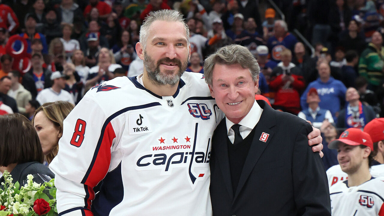 ELMONT, NEW YORK - APRIL 06: Alex Ovechkin #8 of the Washington Capitals poses with former NHL player Wayne Gretzky after scoring his 895th career goal during the second period against the New York Islanders at UBS Arena on April 06, 2025 in Elmont, New York. Ovechkin's goal passes Gretzky's 894 goals to become the NHL all-time goal-scoring leader.