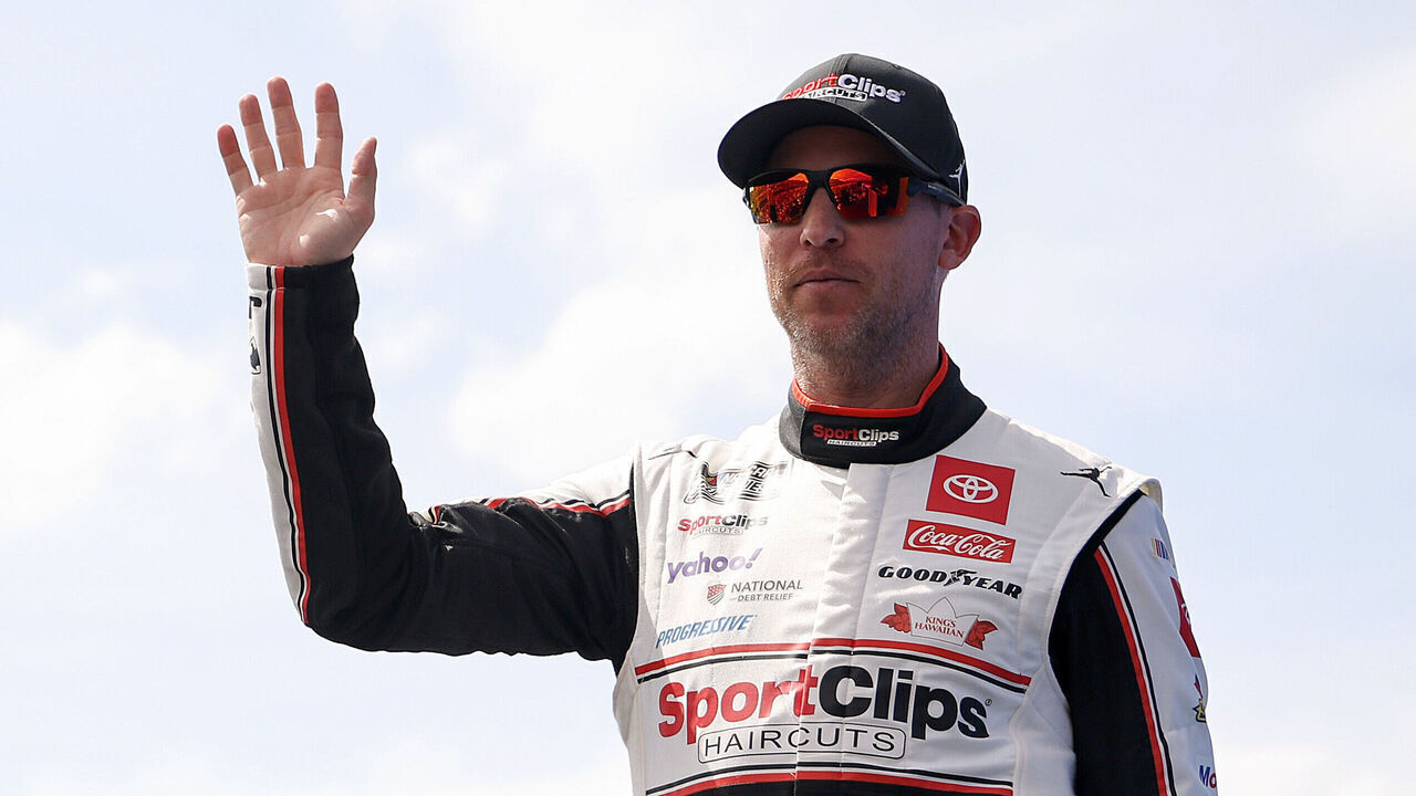 DARLINGTON, SOUTH CAROLINA - APRIL 06: Denny Hamlin, driver of the #11 Sport Clips Haircuts Toyota, waves to fans as he walks onstage during driver intros prior to the NASCAR Cup Series Goodyear 400 at Darlington Raceway on April 06, 2025 in Darlington, South Carolina.