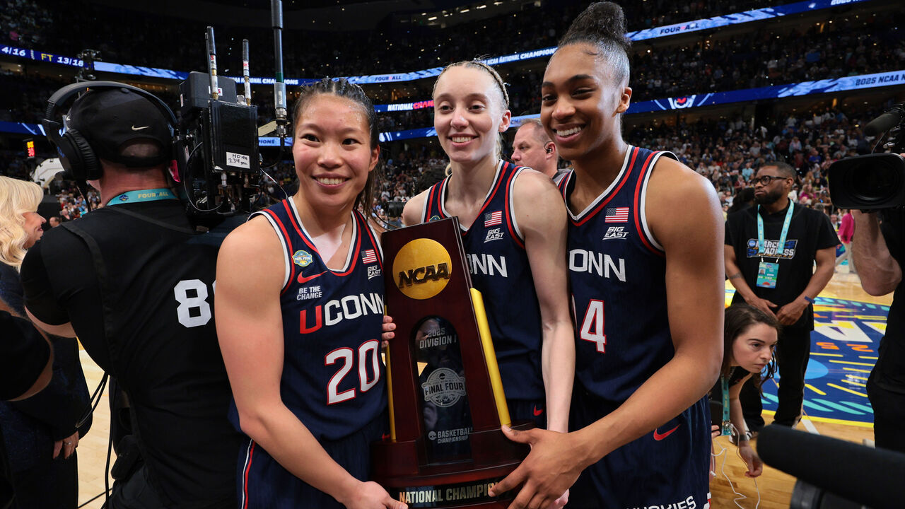 TAMPA, FLORIDA - APRIL 06: Kaitlyn Chen #20, Paige Bueckers #5, and Aubrey Griffin #44 of the UConn Huskies pose for a photo with the trophy after defeating the South Carolina Gamecocks during the NCAA Women's Basketball Tournament championship game at Amalie Arena on April 6, 2025 in Tampa, Florida.
