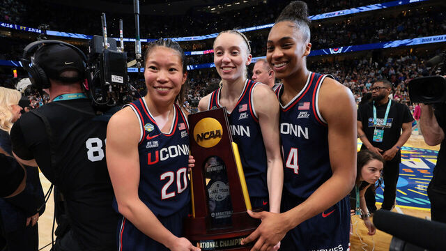 TAMPA, FLORIDA - APRIL 06: Kaitlyn Chen #20, Paige Bueckers #5, and Aubrey Griffin #44 of the UConn Huskies pose for a photo with the trophy after defeating the South Carolina Gamecocks during the NCAA Women's Basketball Tournament championship game at Amalie Arena on April 6, 2025 in Tampa, Florida.