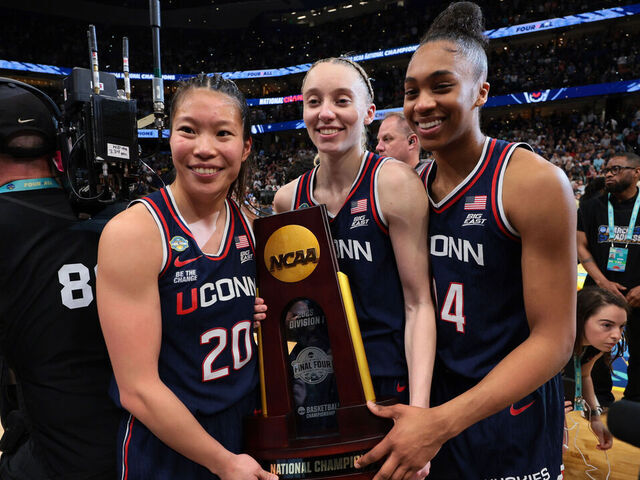 TAMPA, FLORIDA - APRIL 06: Kaitlyn Chen #20, Paige Bueckers #5, and Aubrey Griffin #44 of the UConn Huskies pose for a photo with the trophy after defeating the South Carolina Gamecocks during the NCAA Women's Basketball Tournament championship game at Amalie Arena on April 6, 2025 in Tampa, Florida.