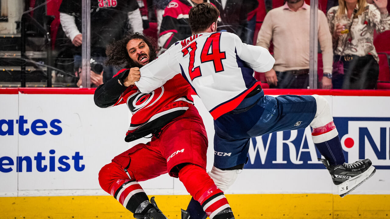 RALEIGH, NORTH CAROLINA - APRIL 02: Jalen Chatfield #5 of the Carolina Hurricanes fights Connor McMichael #24 of the Washington Capitals during the third period at Lenovo Center on April 2, 2025 in Raleigh, North Carolina.