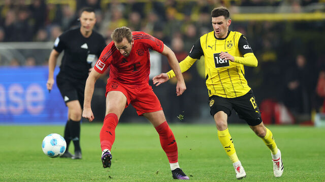 DORTMUND, GERMANY - NOVEMBER 30: Harry Kane of Bayern Munich passes the ball whilst under pressure from Pascal Gross of Borussia Dortmund during the Bundesliga match between Borussia Dortmund and FC Bayern München at Signal Iduna Park on November 30, 2024 in Dortmund, Germany.