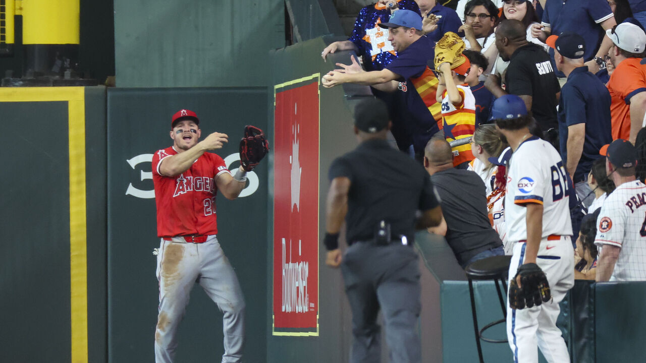 HOUSTON, TX - APRIL 12: Los Angeles Angels right fielder Mike Trout (27) complains to first base umpire Alan Porter (64) after a fan interfered with his catch in the bottom of the second inning during the MLB game between the Los Angeles Angels and Houston Astros at Daikin Park on April 12, 2025 in Houston, Texas.