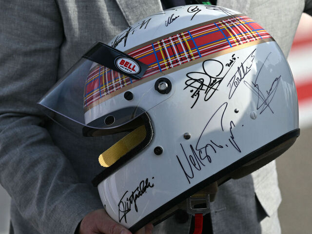 Marc Stewart holds the helmet of his father, the former British Formula One racing driver Jackie Stewart, after the latter performed an exhibition lap ahead of the Bahrain Formula One Grand Prix at the Bahrain International Circuit in Sakhir on April 13, 2025.